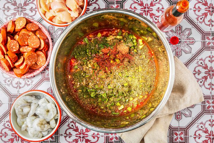 Broth and tomato paste with celery, green peppers, onion, garlic, parsley, basil, oregano, salt and pepper sauce in a cooker