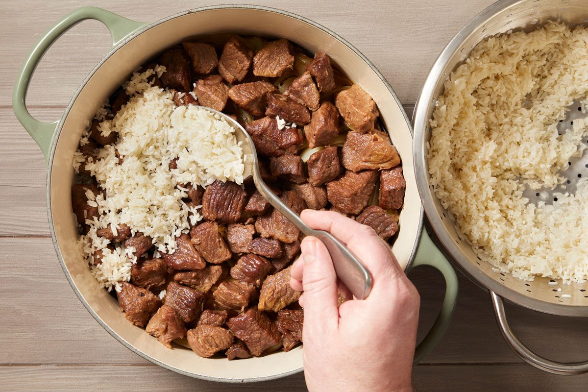 evenly layer rice over lamb.