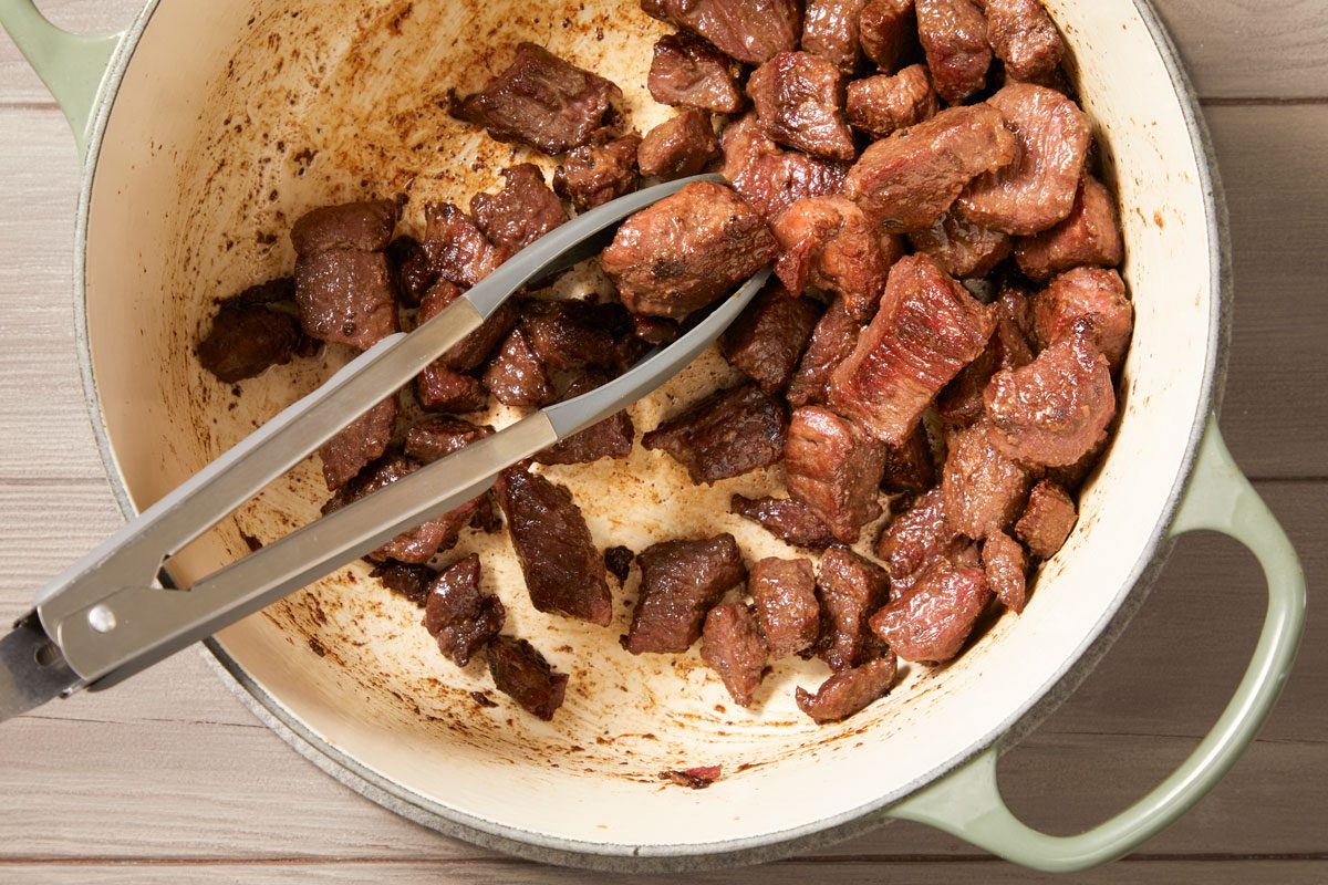 To the same pot, add lamb stew meat, sear stew meat on all sides.