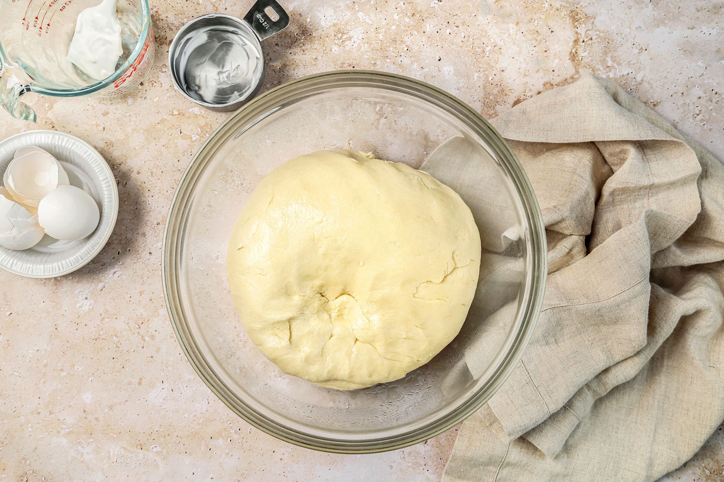 Kneaded dough placed in a greased glass bowl