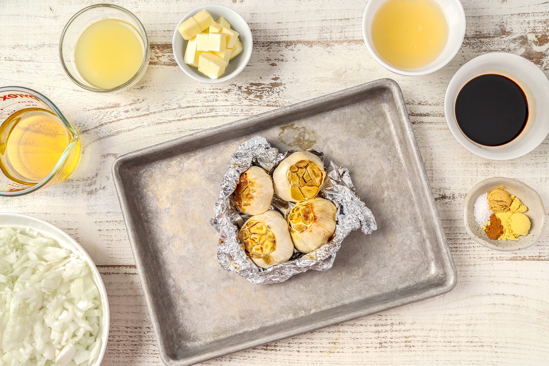 Cut top off garlic bulbs and then brush with oil and wrap each bulb in heavy-duty foil to place on a baking sheet