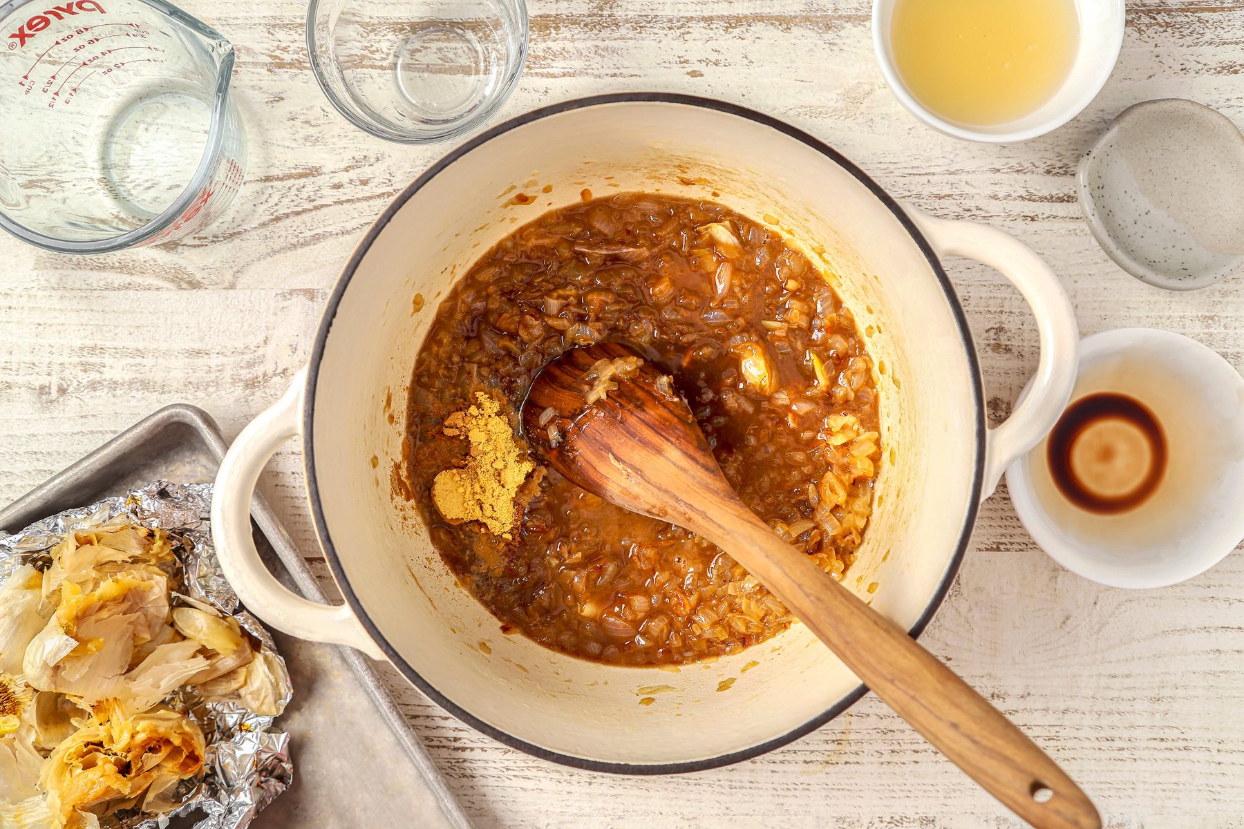 Squeeze softened garlic into Dutch oven and stir in cider vinegar; lemon juice; balsamic vinegar; mustard; salt; pepper; ginger; cloves and sugar