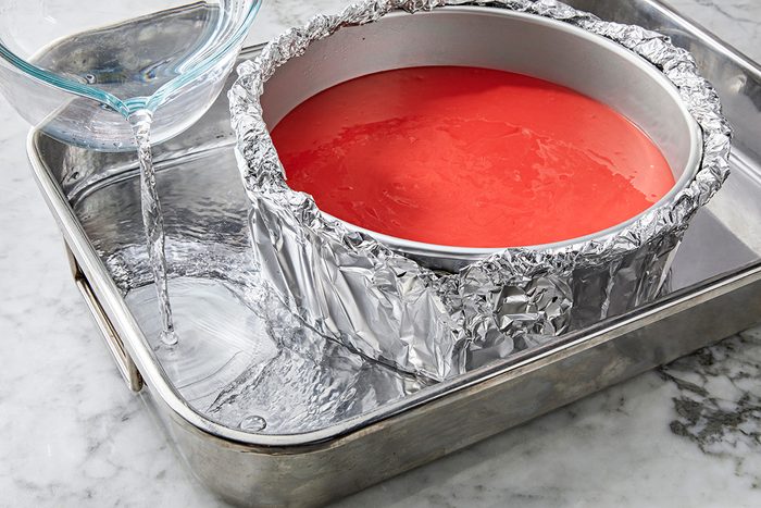 Close shot of place springform pan in a large baking pan; add 1 inch hot water to larger pan; Bake until center is just set and top appears dull, 60-70 minutes; Remove springform pan from water bath; Cool on a wire rack for 10 minutes; Carefully run a knife around inside edge of pan to loosen; cool 1 hour longer; Refrigerate overnight, covering when completely cooled