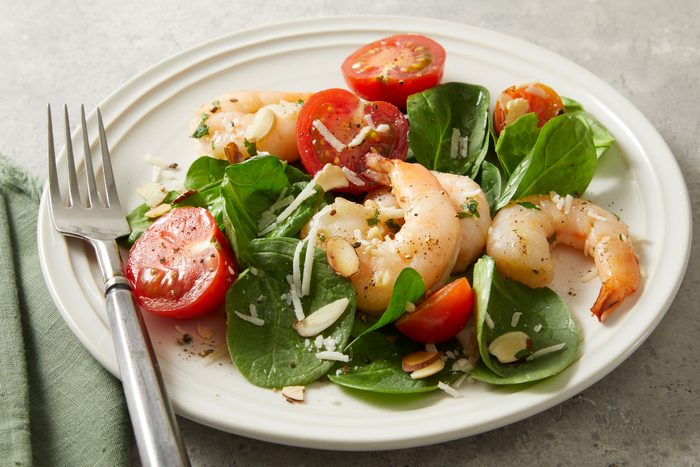 Shrimp Scampi Salad in a white plate with a fork