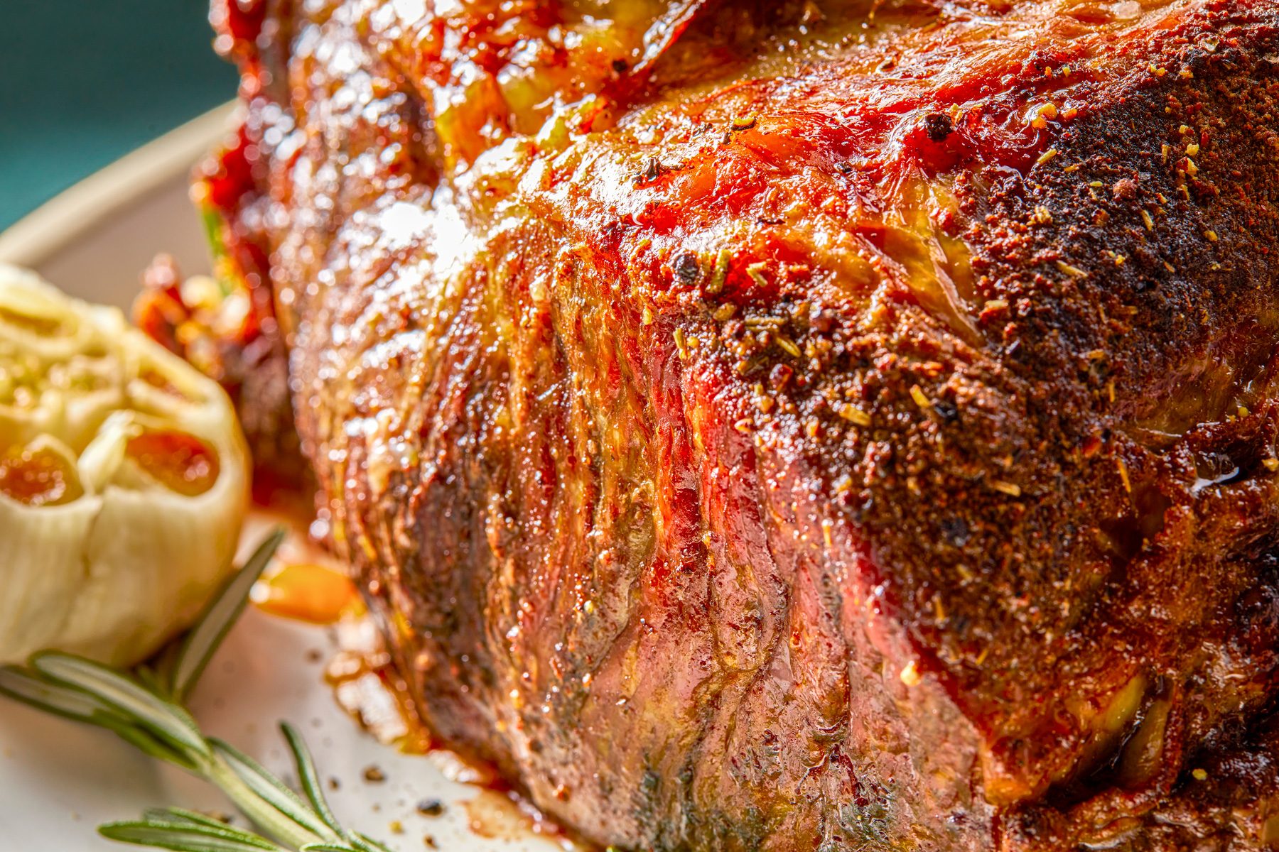 Close up shot of Standing Rib Roast; served on a large plate; with sauce