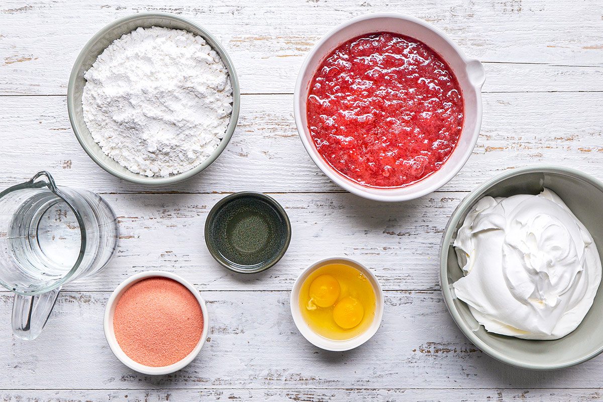 overhead shot of Jell-O Poke Cake ingredients placed over white wooden background