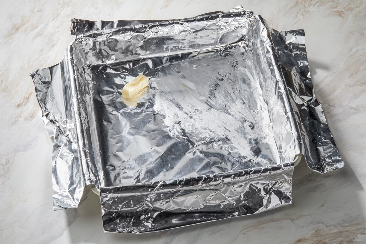 A butter-greased, foil-lined 9-inch square pan.