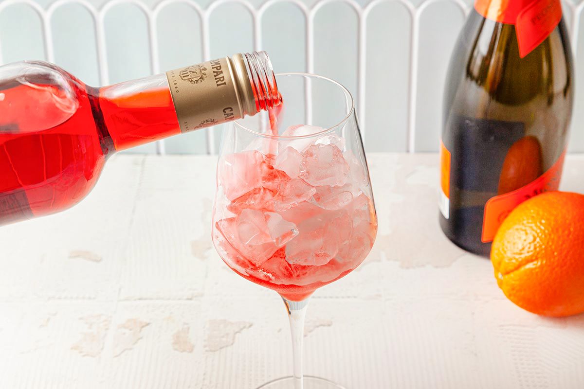 Campari is being poring over the ice in wine glass
