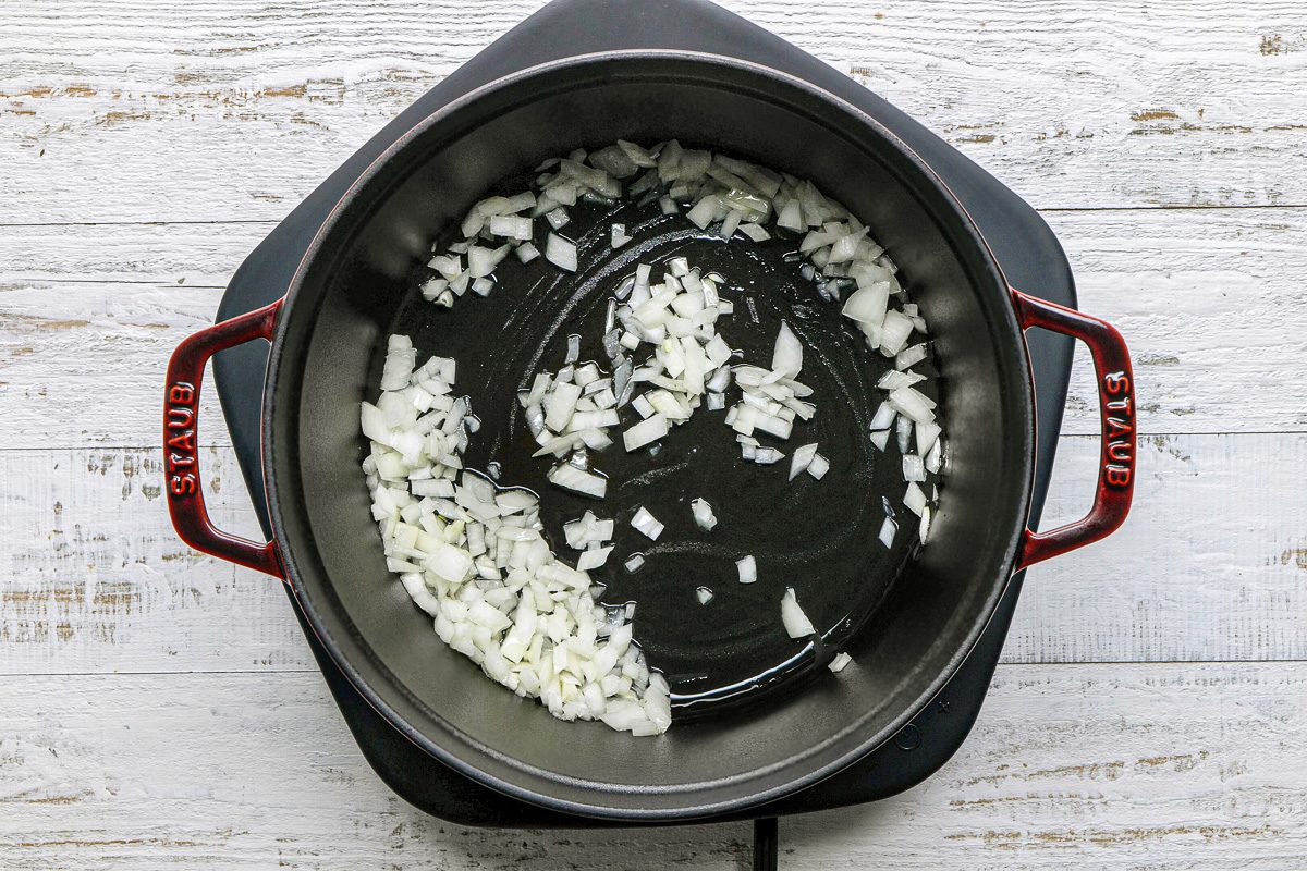 onions being sauteed in a dutch oven