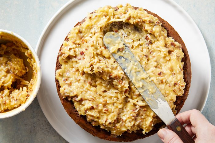Coconut Pecan Frosting being spread over cake