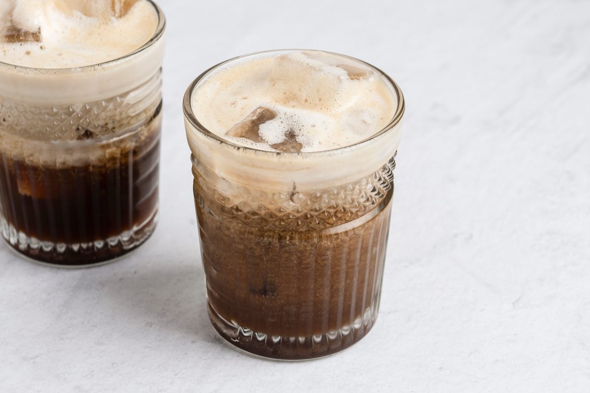 Close shot of Copycat Starbucks Apple Crisp Oatmilk Shaken Espresso; served in glasses; white surface;