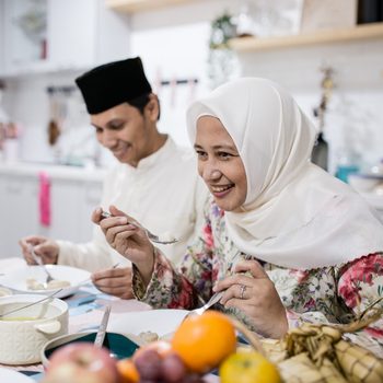 Family, celebrating Eid-al-Fitr, having a meal together in their kitchen