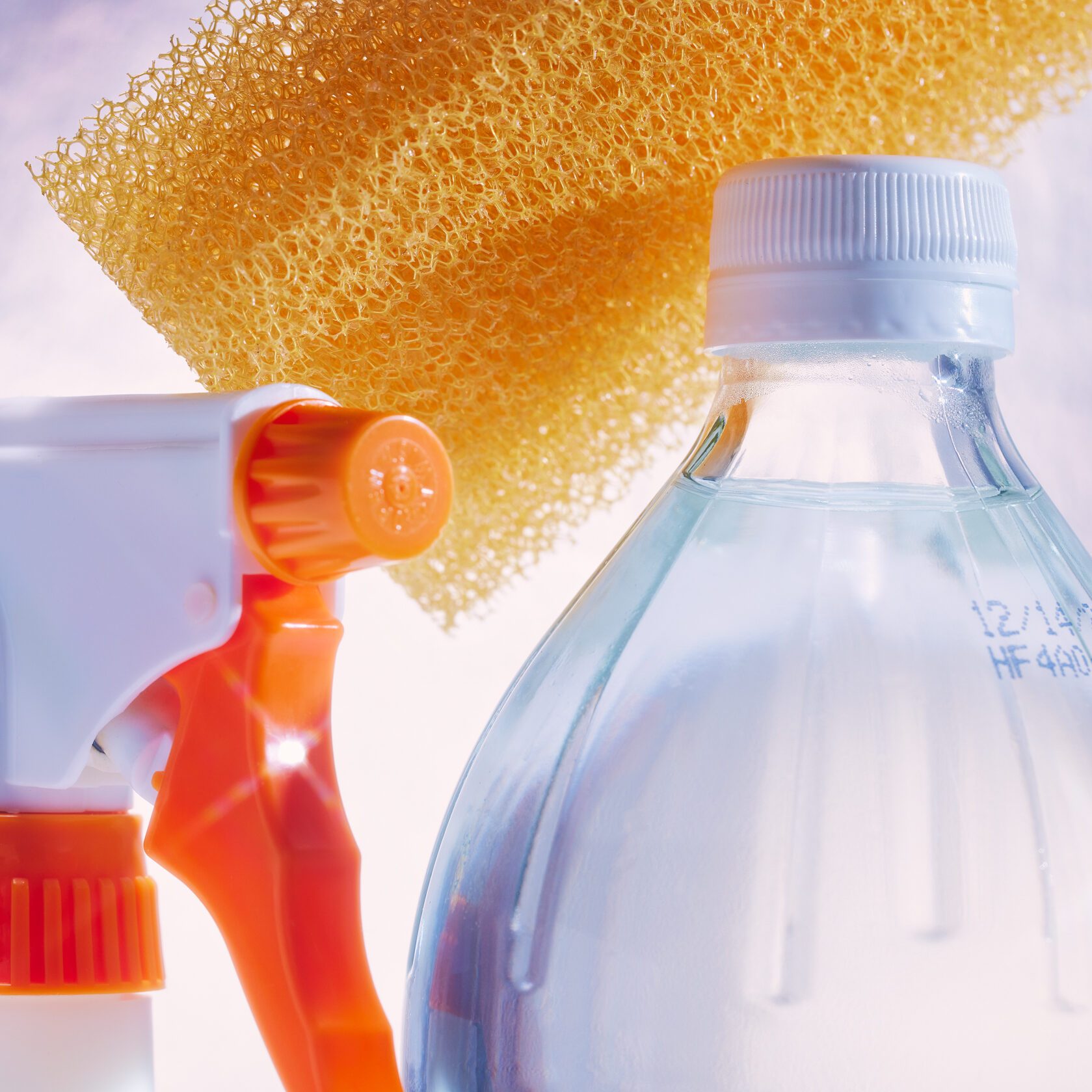 Spray bottle and sponge with a bottle of white vinegar