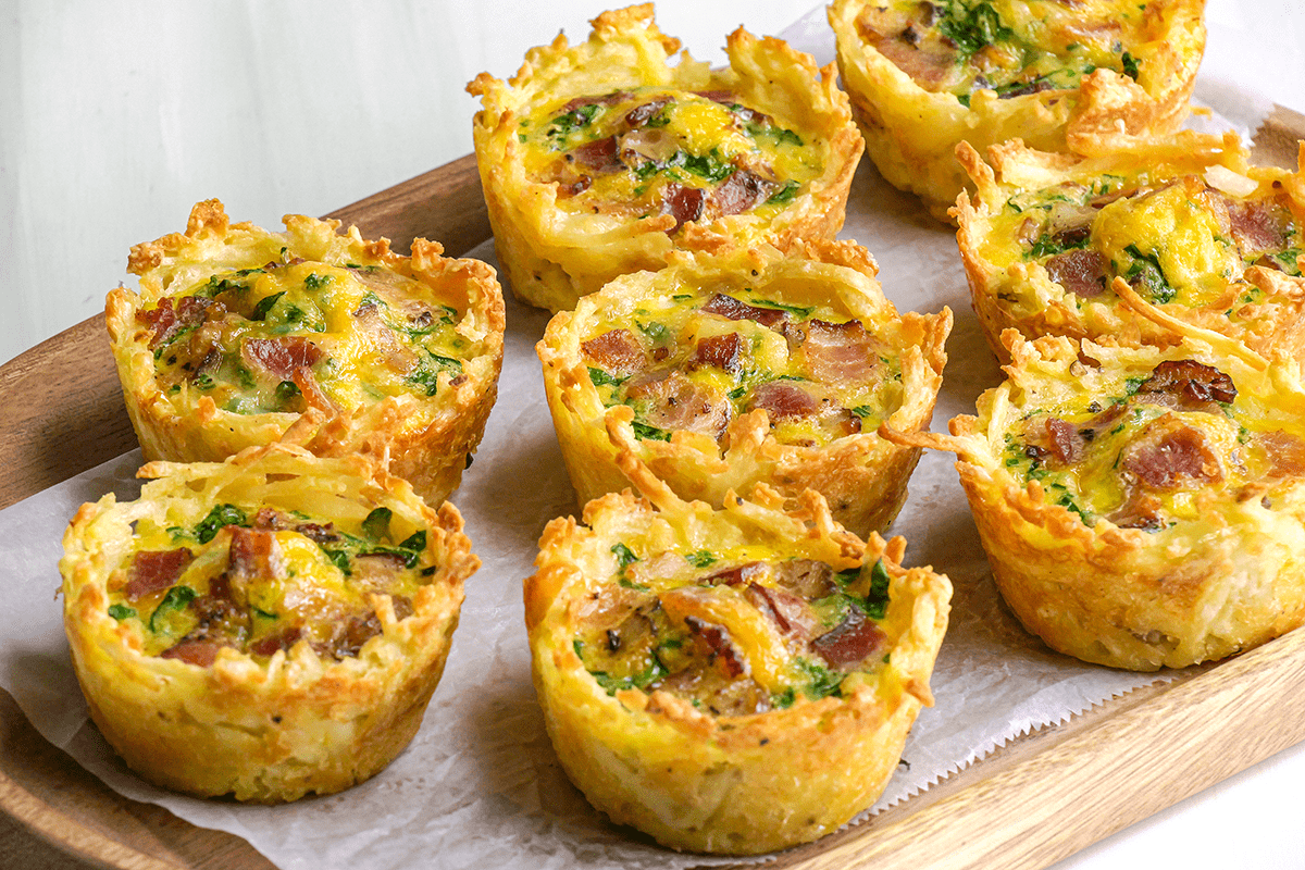 Close shot of Hash Brown Quiche Cups, served on wooden tray