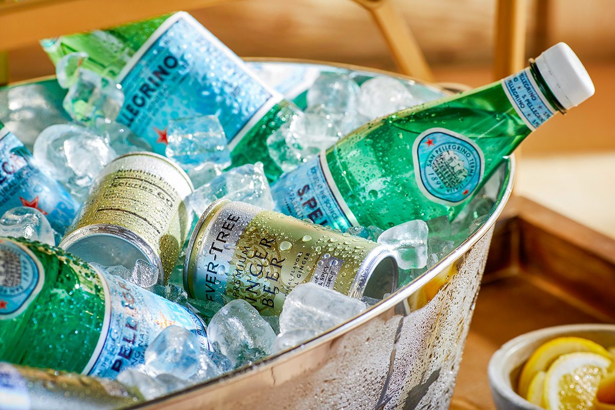 Various canned drinks and soda are placed in ice bucket