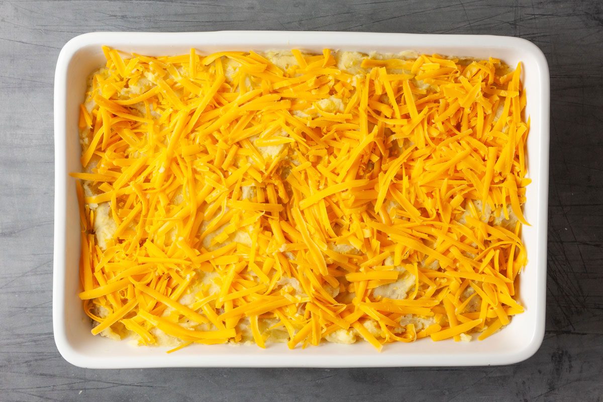 Scoop the mash into a lightly greased 13x9-inch pan and and sprinkle with the grated sharp cheddar cheese