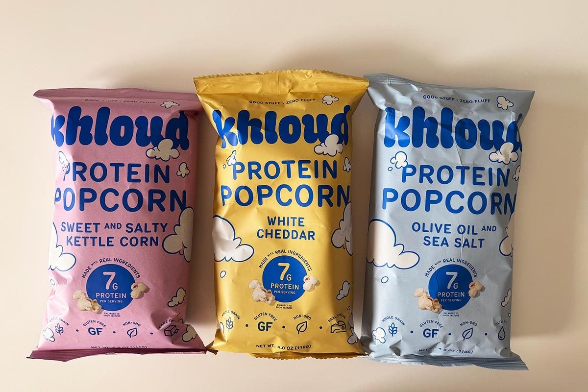 Kettle, White Chedder and Olive Oil Sea Salt flavored packages of Khloud Popcorn