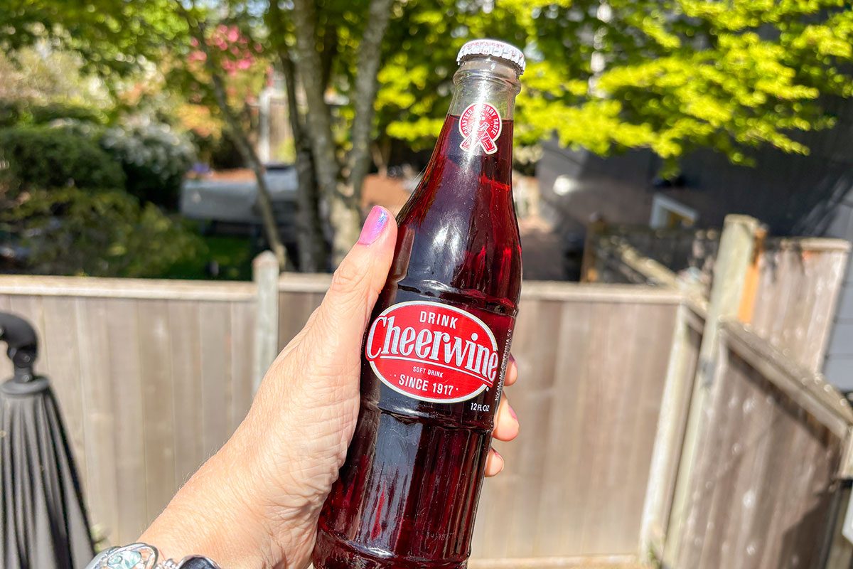 A person holding a cheerwine drink bottle