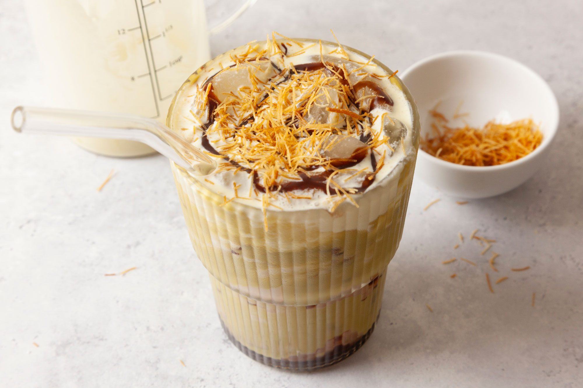 Garnish with a final drizzle of chocolate syrup; top with toasted kataifi