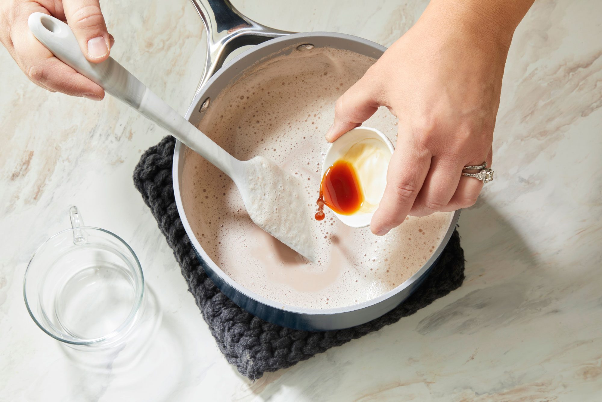 Overhead shot of remove saucepan from the heat; stir in vanilla; Ladle into mugs; spatula; marble surface