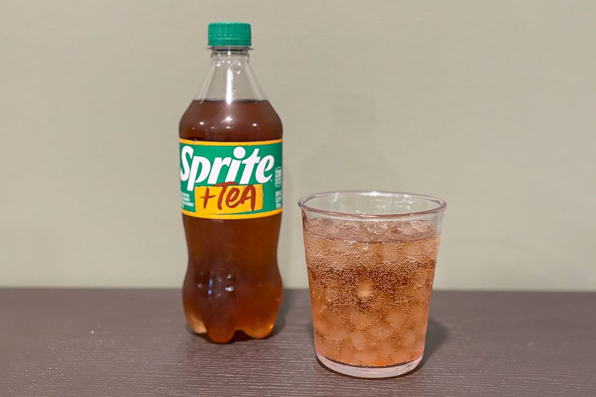 Sprite + Tea beverage bottle on a table with glass filled with it