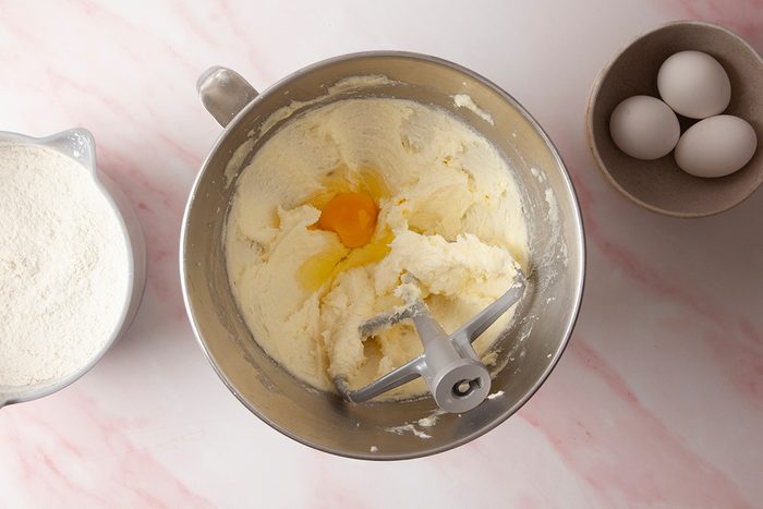 In a large bowl whisk together flour; baking powder; salt and in another bowl mix cream butter; sugar and add eggs one at a time mixing well after each addition