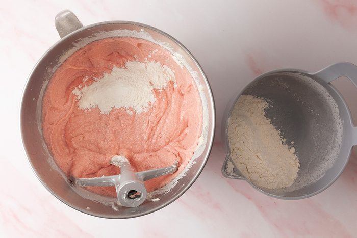 Add milk; strawberry puree; strawberry gelatin; vanilla and half of the flour mixture