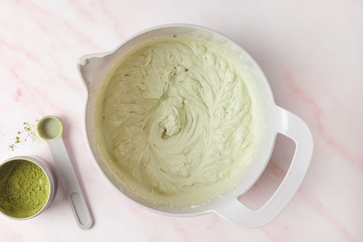 heavy cream, granulated sugar, vanilla and sifted matcha powder being beated in a bowl