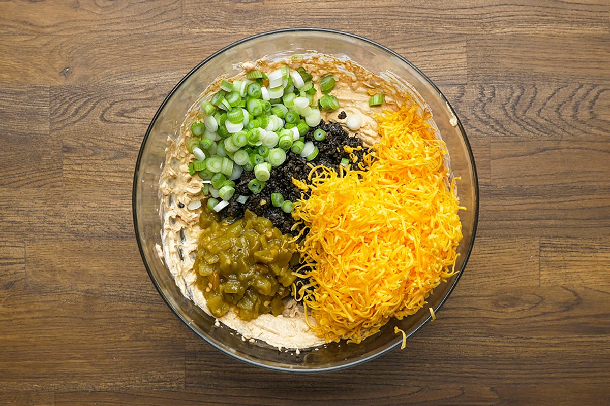 Overhead shot of stir in olives; chiles; cheese and green onion