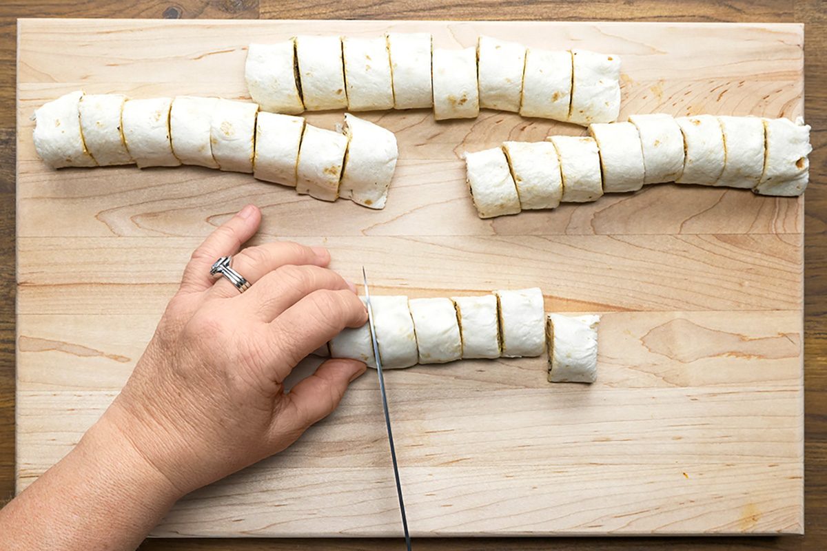 Overhead shot of slice into 1-inch pieces on wooden board with knife; Serve with salsa