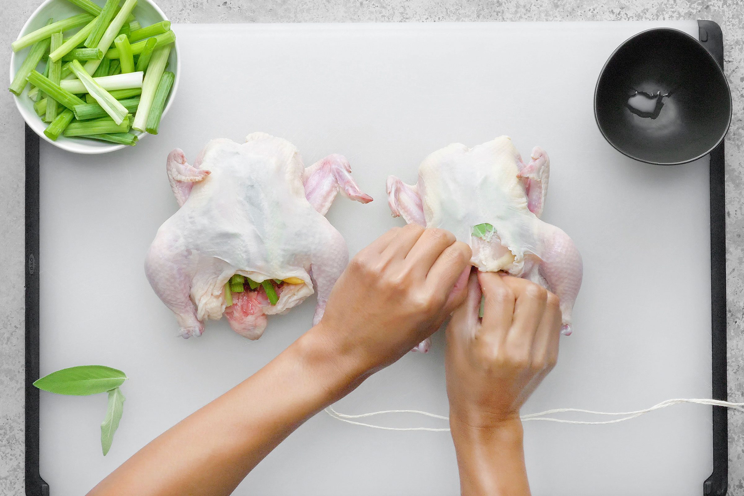 Inserting the lemon wedges and a third of the onions into the cavities
