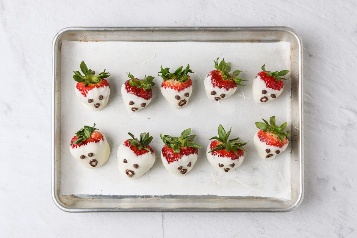 Dip a toothpick into melted chocolate and draw a mouth on each ghost.