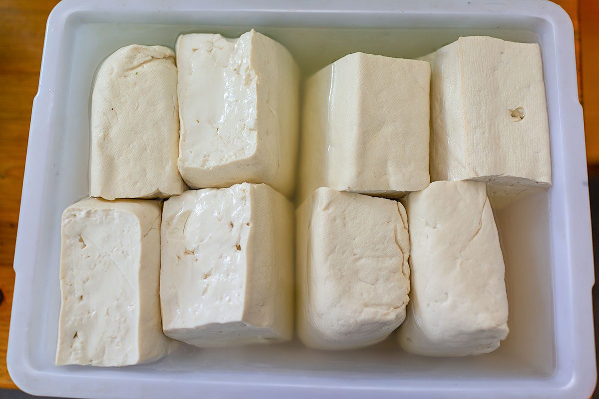Tofu putting in water in plastic tray