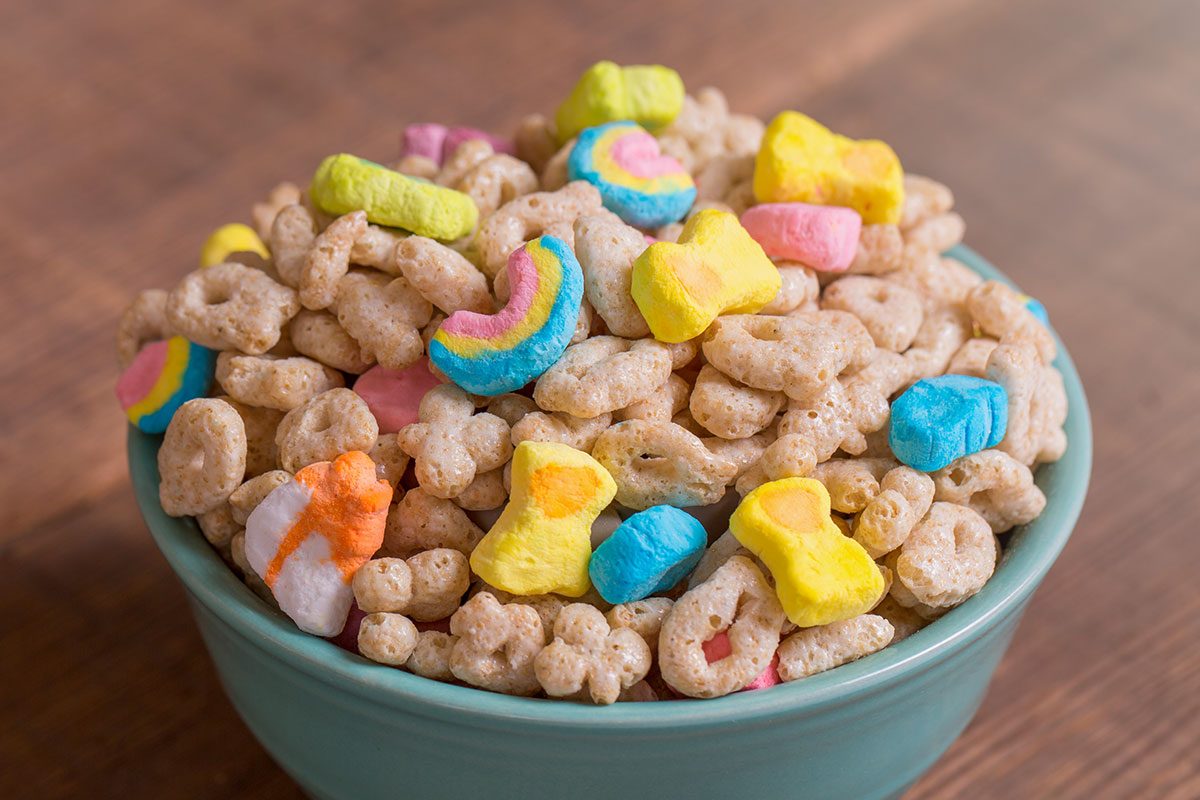 Colorful marshmallow cereal in a blue bowl on a weathered wood background
