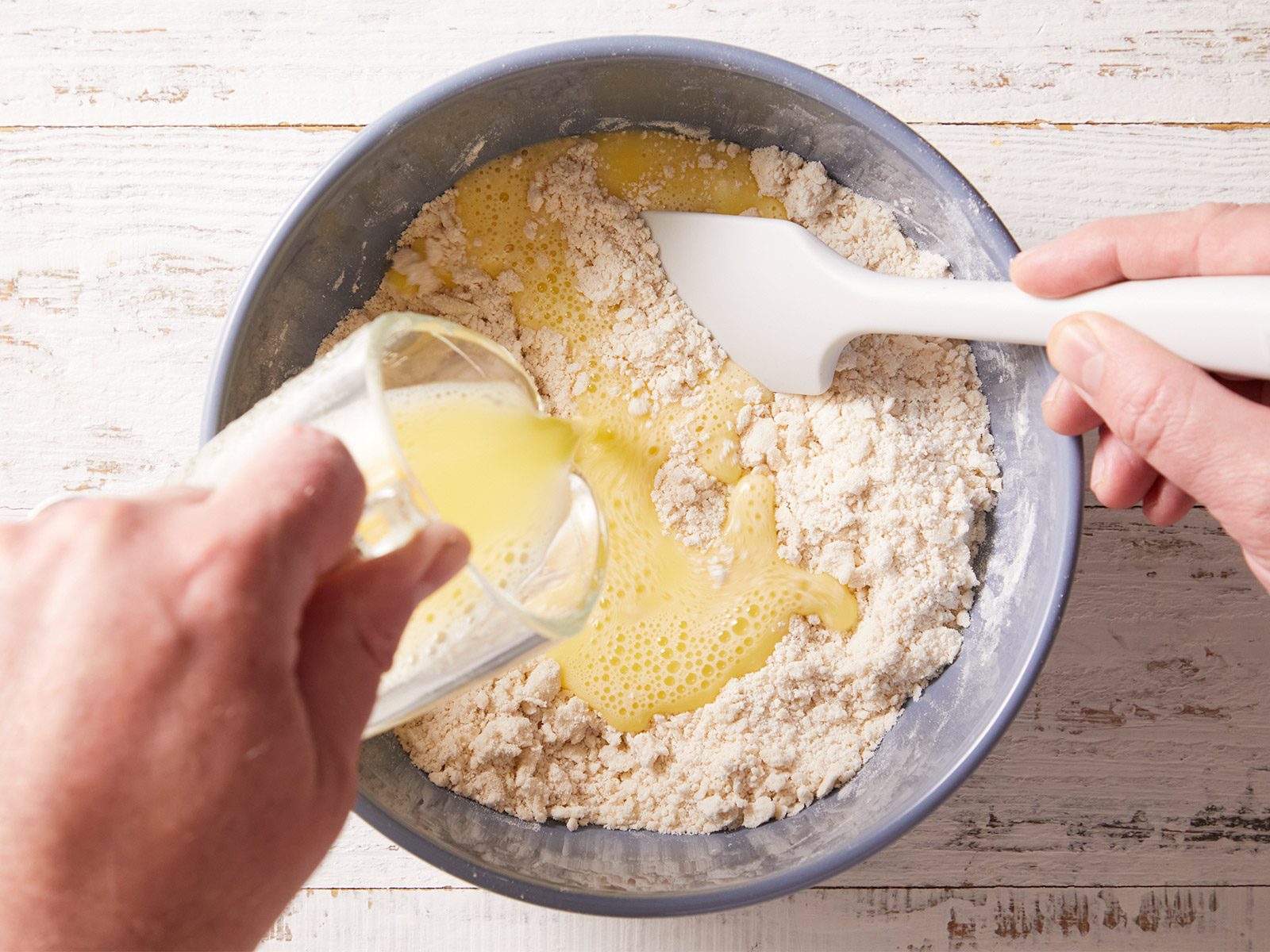 Overhead shot of In a small white bowl, whisk egg, water and vinegar; gradually add to crumb mixture using a spatula.