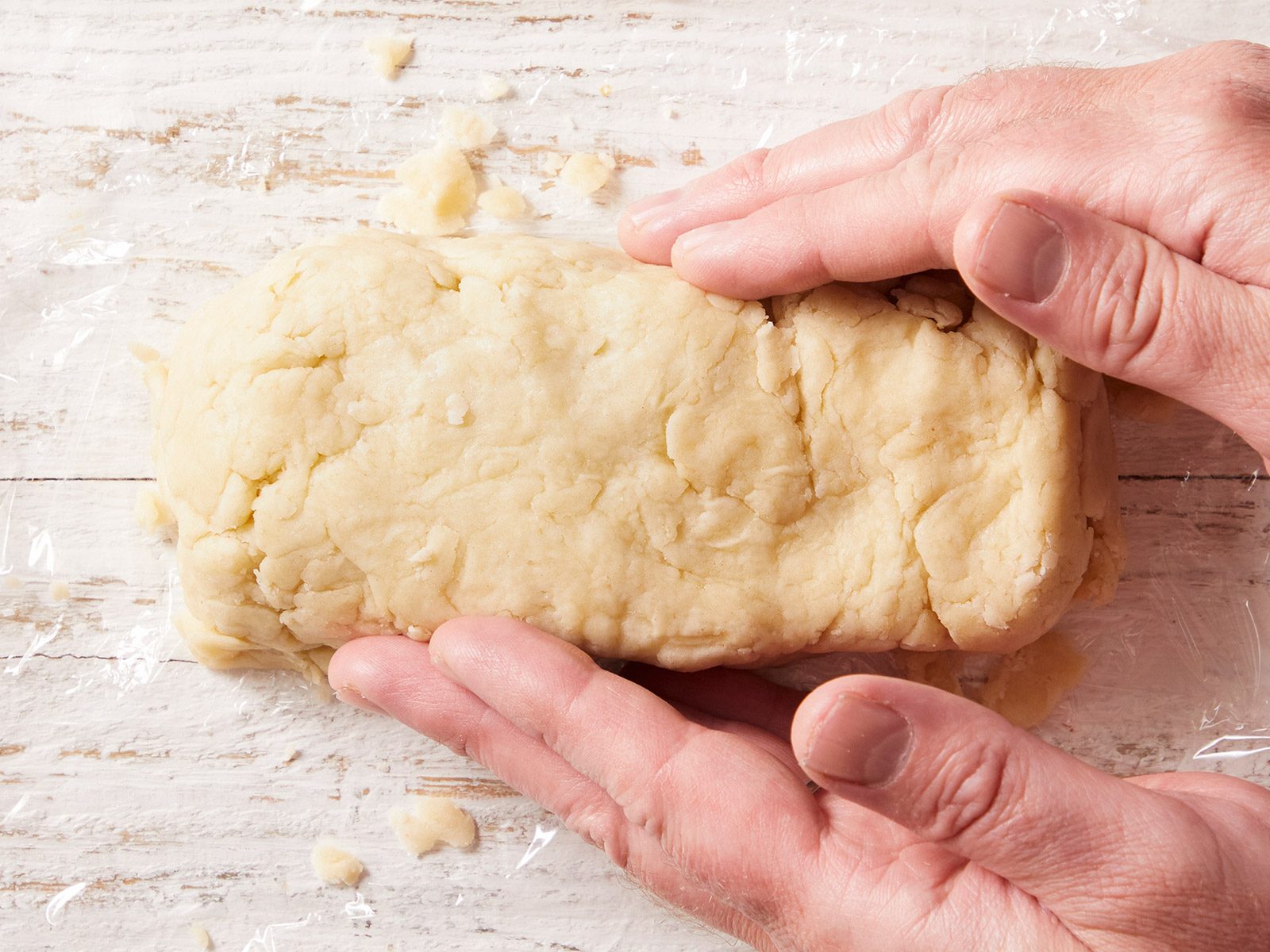 Overhead shot of tow hands shaping the dough into a rectangle.