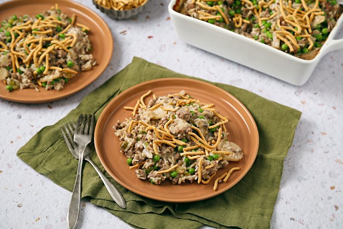 Chinese Casserole served on an orange plate with a fork kept on side. Plate is kept on an olive green kitchen cloth.
