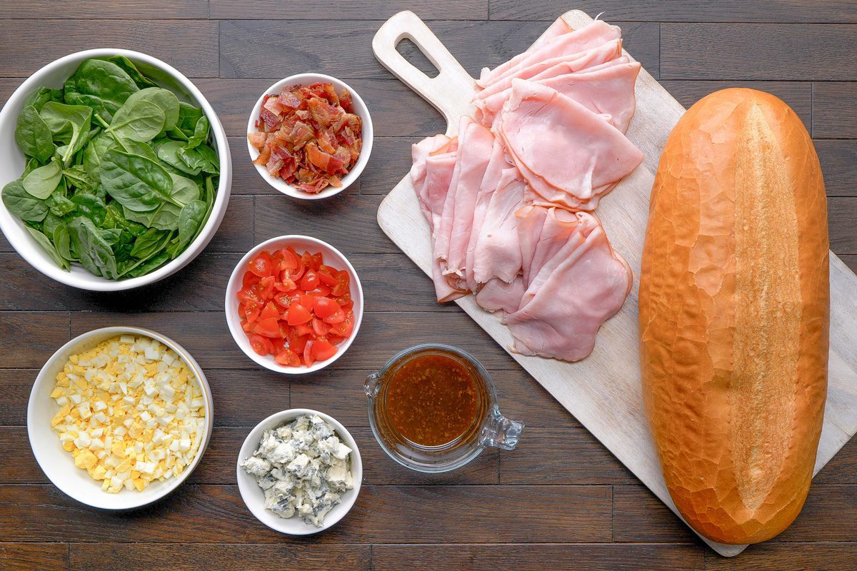 Italian bread, Balsamic vinaigrette, Baby spinach, Deli ham, Hard-boiled eggs, Bacon strips, Gorgonzola cheese, Cherry tomatoes