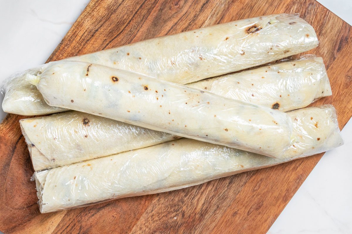 Closeup shot of refrigerate for at least 1 hour; Cut each roll-up into 10 slices on wooden board; all et on a white marble surface;