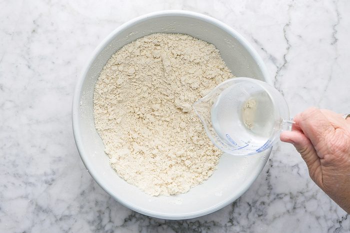 adding water to pastry mix in a bowl