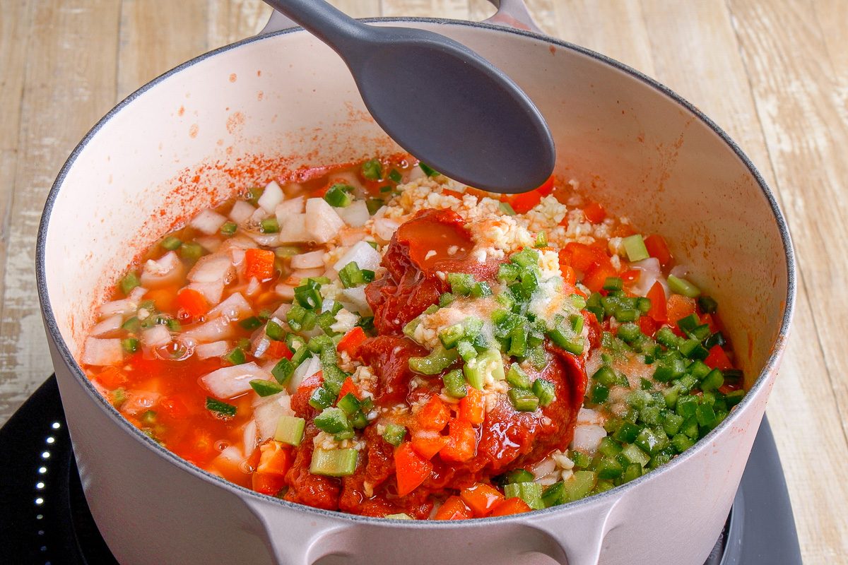  mixing green peppers, onions, tomato paste, vinegar, sugar, red pepper, celery, garlic, jalapenos, canning salt, hot pepper sauce and reserved tomato liquid