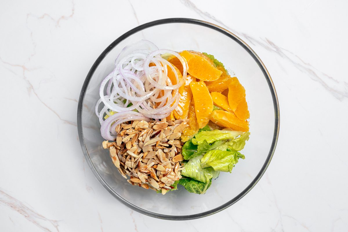 lettuce, orange sections, onion slices and almonds combined together