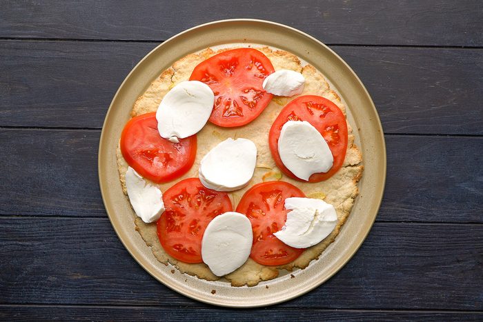 thinly sliced tomato and sliced fresh mozzarella added to dough