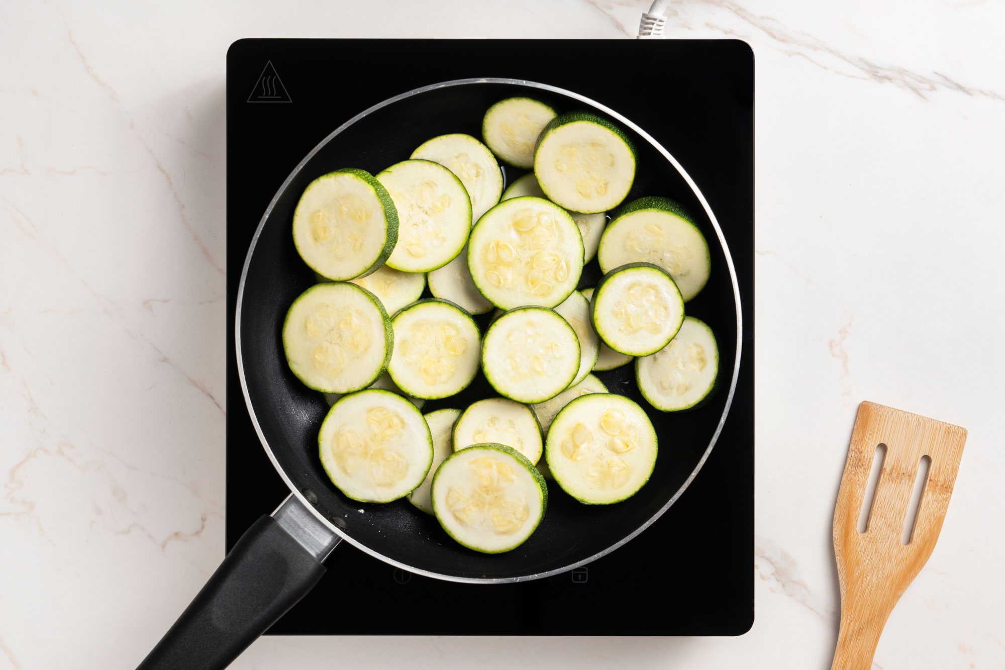 In a large enamel-coated cast-iron or other heavy skillet, heat oil over medium-high heat. Add zucchini
