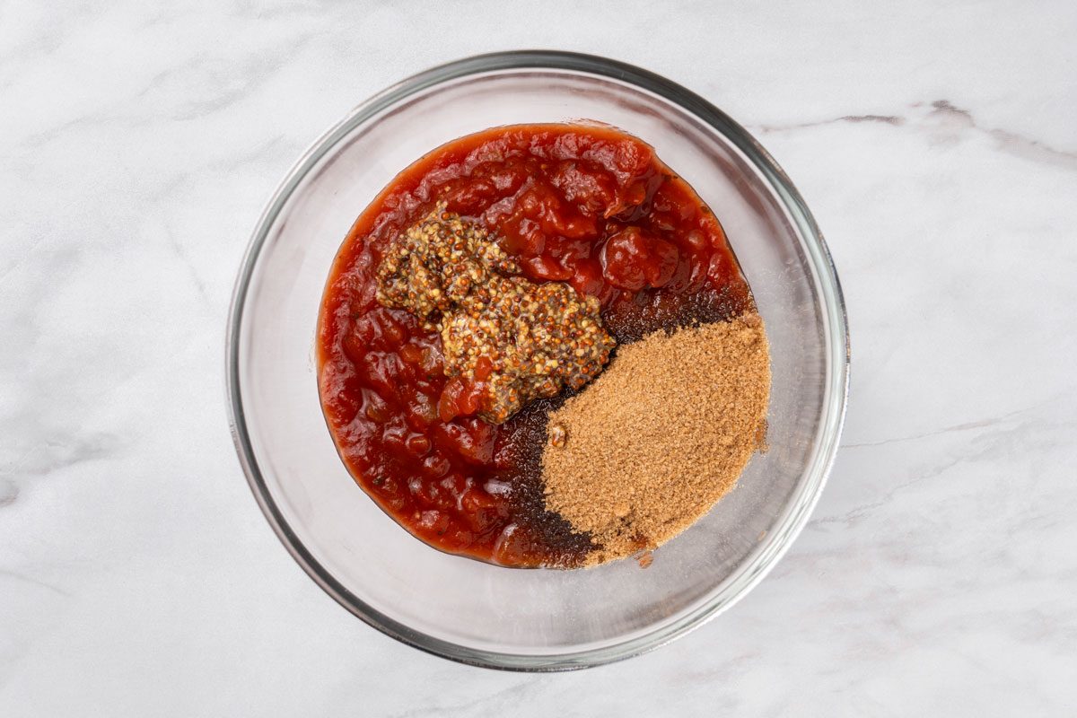 Overhead shot of a small bowl; combine the picante sauce, brown sugar and mustard; all set on a marble surface;
