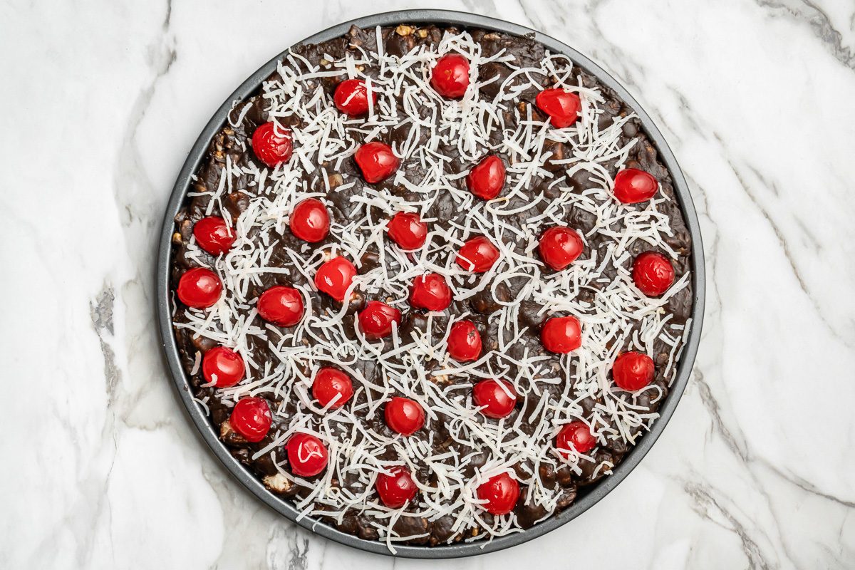 pizza base sprinkled with coconut and cherries