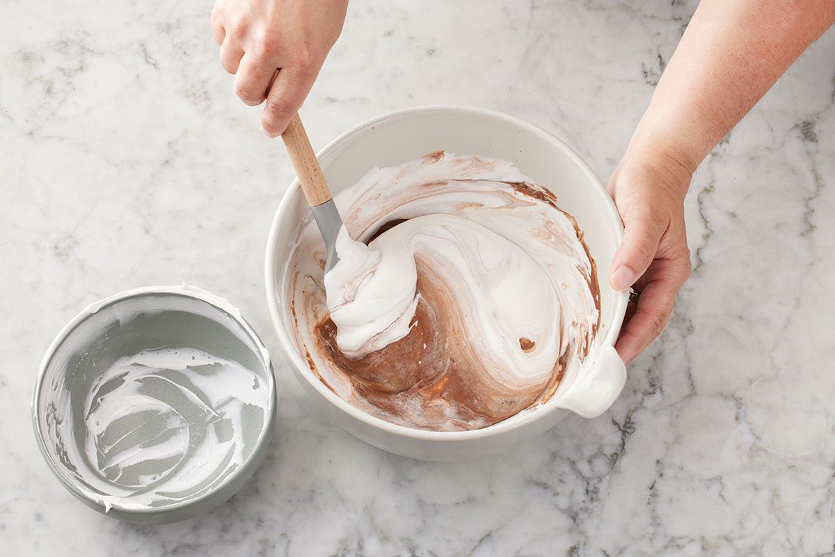 Chocolate pudding mix and cold milk being mixed in the large bowl
