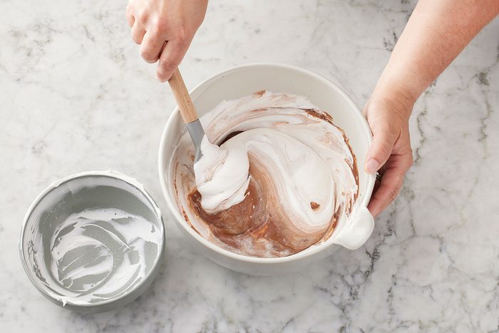 Chocolate pudding mix and cold milk being mixed in the large bowl