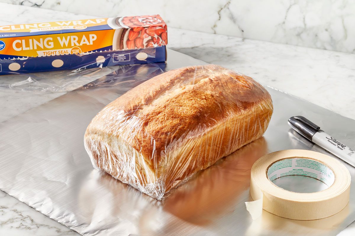 tape and marker next to bread wrapped in plastic wrap