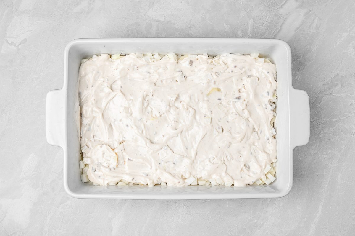 layers of sliced potatoes and chopped onions sprinkled with salt and pepper